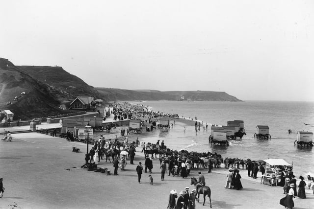 circa 1913: Day-trippers on the North Beach at Scarborough where they are offered rides, bathing machines and a souvenir stall, as well as the beach itself.