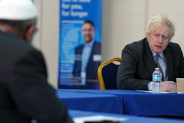 Prime Minister Boris Johnson speaks to members of staff as he visits a COVID-19 vaccination centre in Batley,