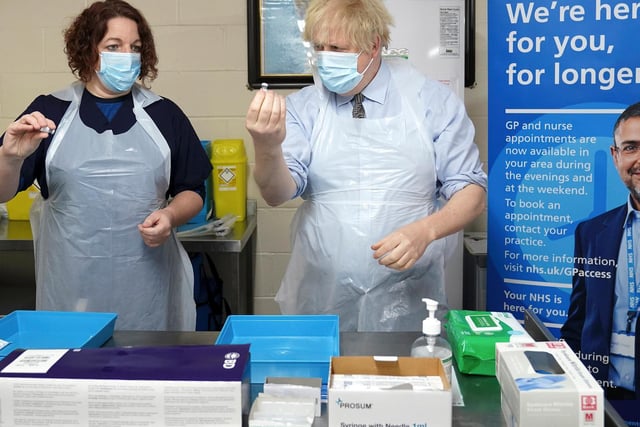 Prime Minister Boris Johnson is shown how to prepare the vaccine by advance nurse practitioner Sarah Sowden