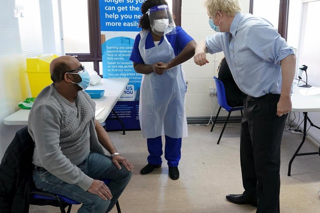 Prime Minister Boris Johnson greets doctor Chantelle Ratcliffe before she administers the vaccine to Ismail Patel
