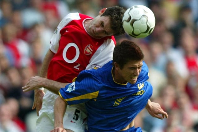 Arsenal's Martin Keown wins an aerial battle with Harry Kewell.