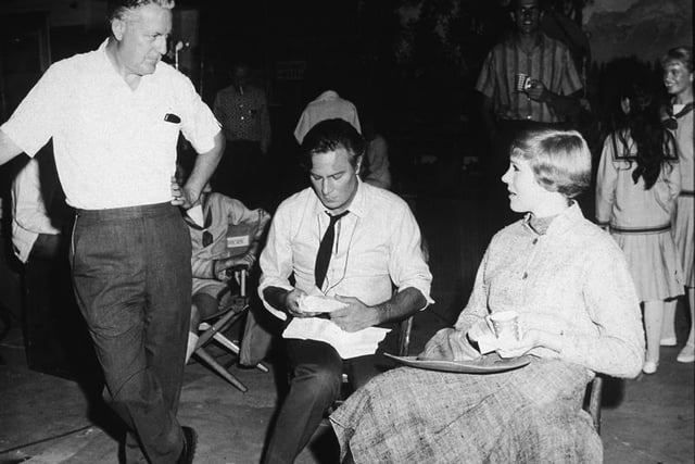 American film director Robert Wise (standing), Canadian actor Christopher Plummer, and British actress Julie Andrews talk during a lunch break on the set of the film verssion of 'The Sound of Music,' 1965