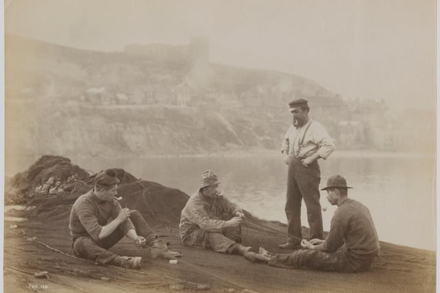 Fishermen mending their nets in Whitby, North Yorkshire, circa 1890.