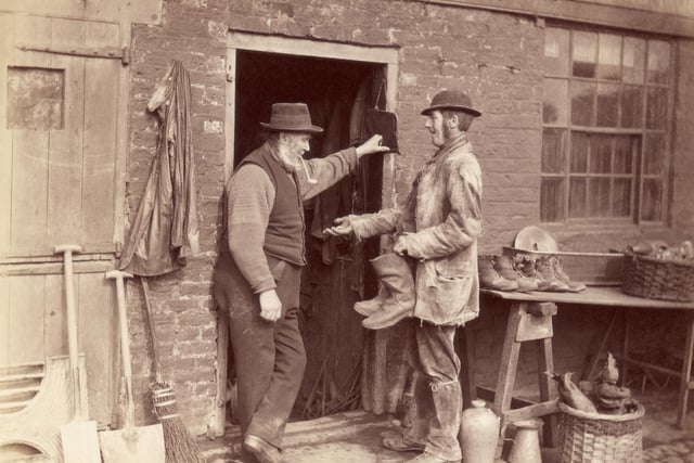 circa 1880: A man buying a pair of boots from a secondhand shop.