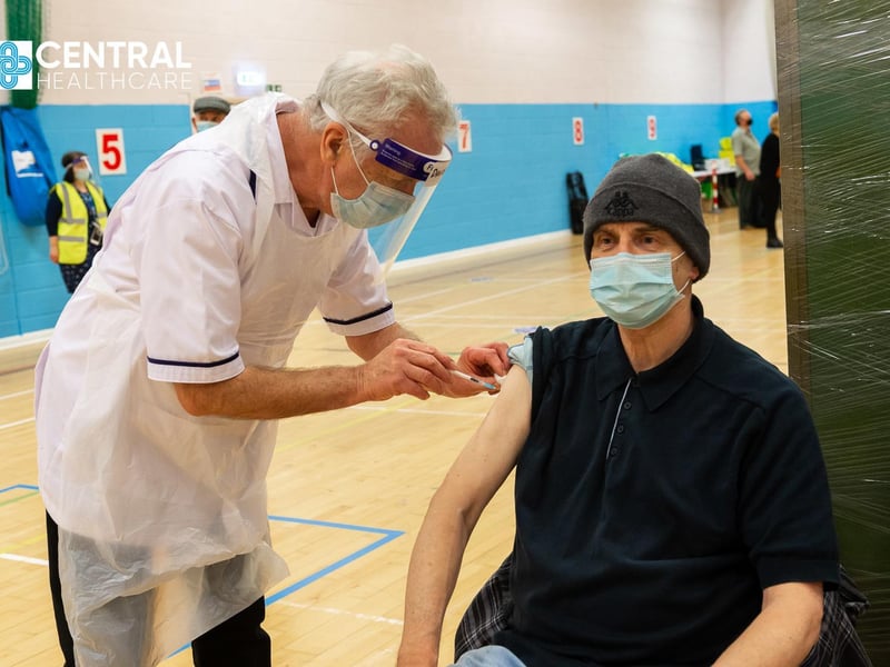 Nurse David Wilson, 69, who has come out of retirement to help with the vaccination programme, gives John Nicholson his immunisation.