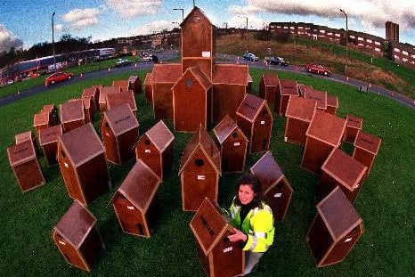 Artist Gill Russell with her Cardboard City on the Leeds Ring Road roundabout near Pudsey.