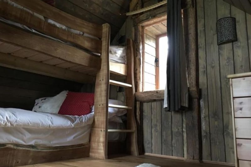 One of the bedrooms features a wooden bunkbed high in the trees