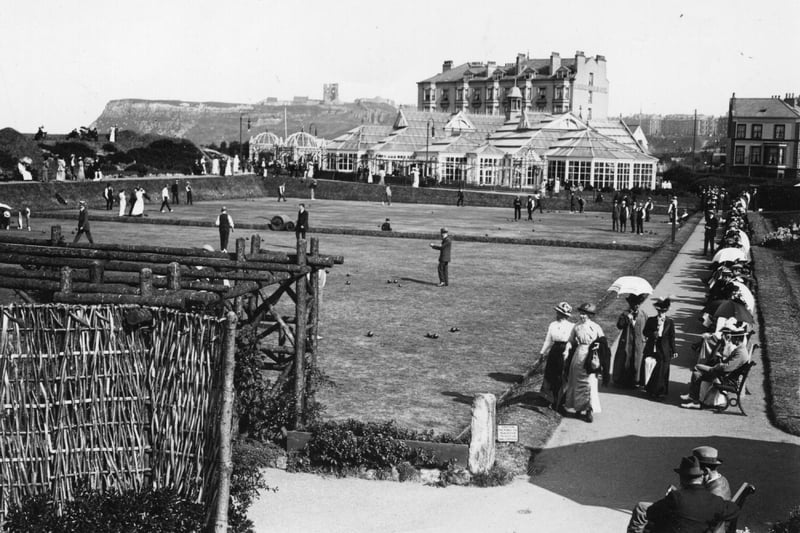 circa 1890: The bowling green at Alexandra Gardens, Scarborough, with the Floral Hall in the background.