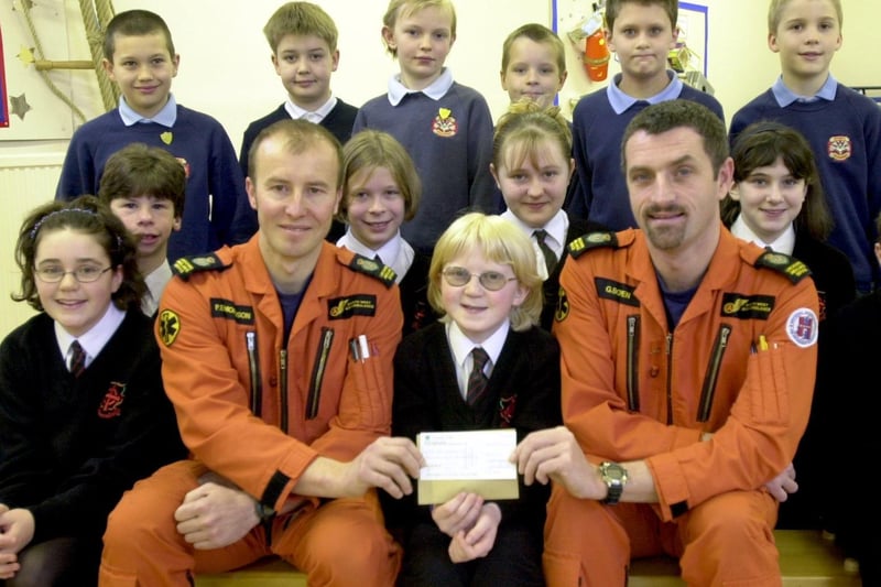 Air Ambulance Flight Crew Graham Bowen and Phil Edmondson, receive a cheque for £300 from pupils of Brinscall St Josephs RC School who held a silly hat day in memory of a fellow pupil, Siobhan Wilcox. Some of her classmates, who are now at Holy Cross High School, came back to make the presentation