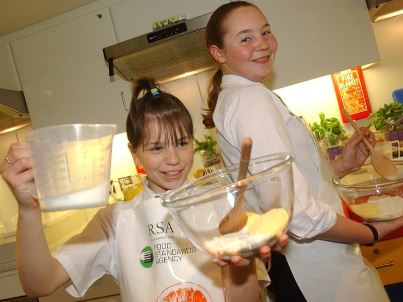 April 2004 and Morley High School pupils - Nicole Beck (left) and Rhian Turner - how off their skills on the Food Standards Agency cooking bus.