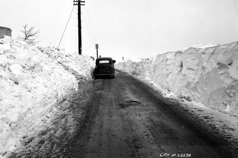 The depth of snowfall is evident in this view of Cookridge Lane after a snow plough has cleared the road. To the left the water tower can be seen.