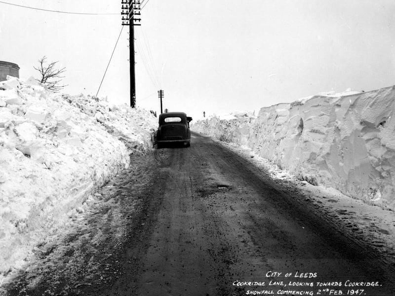 The depth of snowfall is evident in this view of Cookridge Lane after a snow plough has cleared the road. To the left the water tower can be seen.