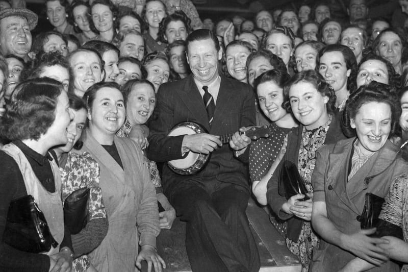 English entertainer George Formby amongst the crowd of war workers, during a free concert in the north of England in October 1940.