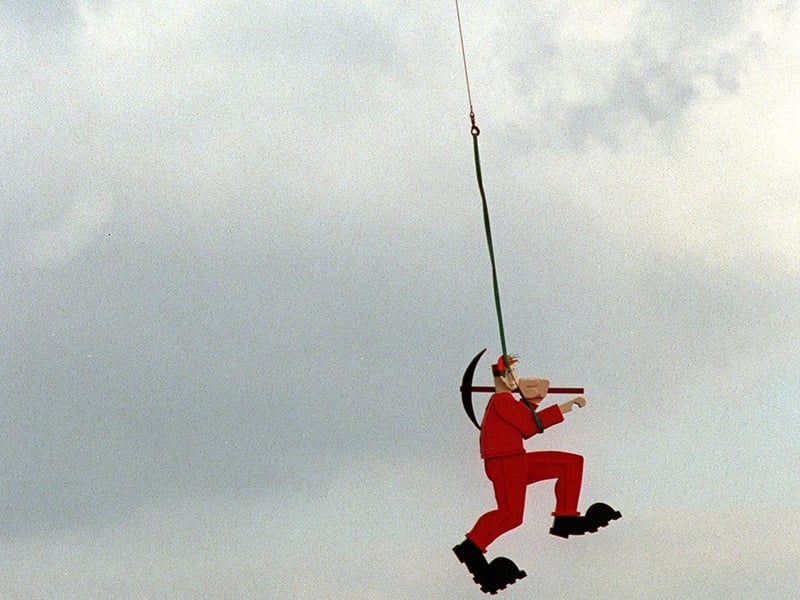 A helicopter airlifts part of the sculpture into position alongside the M1.