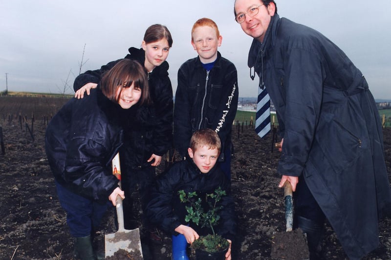 Steve Cottrell, deputy development manager of Miller Mining, helps children from Newlands Primary and Morley High  School plant a Millennium Wood at the former Grove Farm Opencast mining site near Morley.