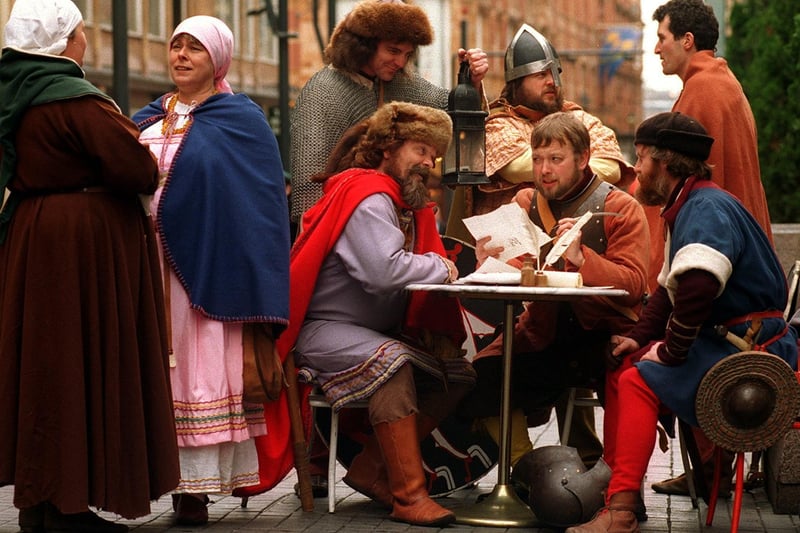 A group of actors in period costume decide on a battle plan for the display's they will be staging.