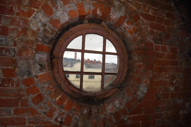 A round window on the top floor, looking out across the town.