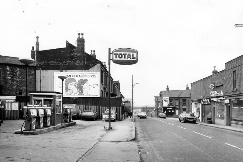 February 1980 and pictured is a view looking north-west along Domestic Street towards the railway viaduct in the distance. On the left is the forecourt of a petrol filling station.