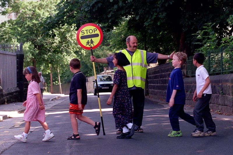 School crossing patrol officer Stuart Smith helps pupils at Christ Church Co of E School get across the road safely in July 1999.