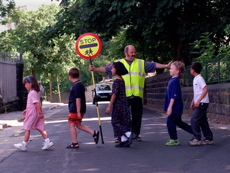 School crossing patrol officer Stuart Smith helps pupils at Christ Church Co of E School get across the road safely in July 1999.
