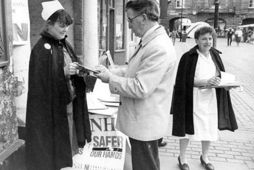 A nurses' protest on Market Place, Pontefract M.P., Geoff Lofthouse, signs their petition