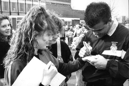 A press photograph of Castleford's Jeff Hardy autographing Fiona Taylor's hand at the hospice gala