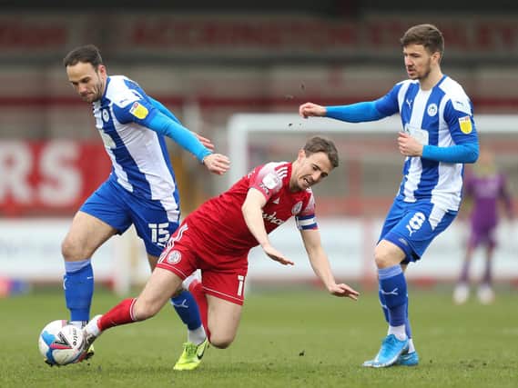 Sean McConville of Accrington Stanley is challenged by Dan Gardner of Wigan Athletic during the Sky Bet League One match between Accrington Stanley and Wigan Athletic at The Crown Ground on March 20, 2021 in Accrington, England.
