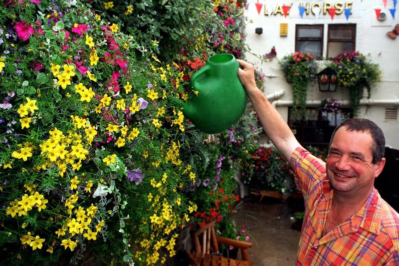 Landlord Vernon Marston tends to his floral display at The Bay Horse pub.