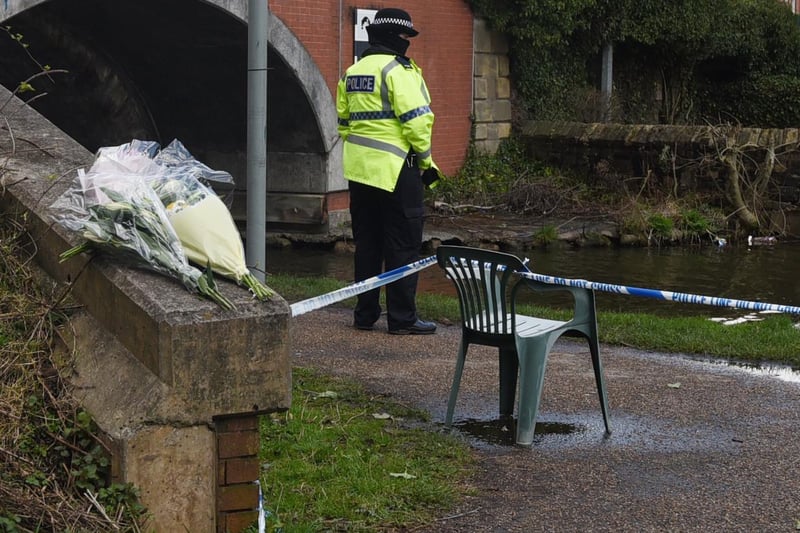 Flowers left near the scene with the police cordon still in place.