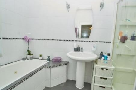 Modern suite compring of a Jacuzzi bath, walk in shower cubicle with power jets, pedestal wash hand basin, low level WC, chrome heated towel rail, fully tiled walls, tiled flooring, frosted triple glazed window.