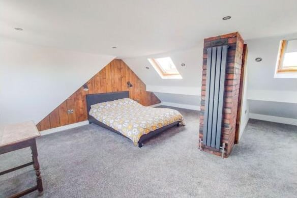 A door opens to a turning staircase leading to the second floor loft conversion, which is used as a spacious master bedroom.  The bedroom has a feature timber wall and an exposed brick chimney breast, while the dormer window has views over the garden and a skylight allows more light into the room.