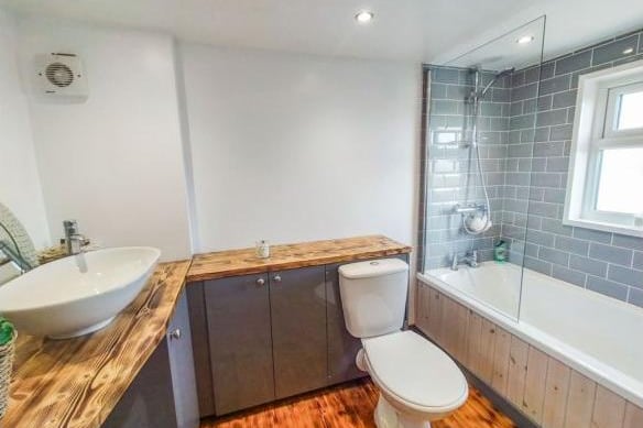 The high specification bathroom has a bath and a mains shower and screen, and is fitted with wooden worktops, a contemporary sink and a beautiful wooden floor.