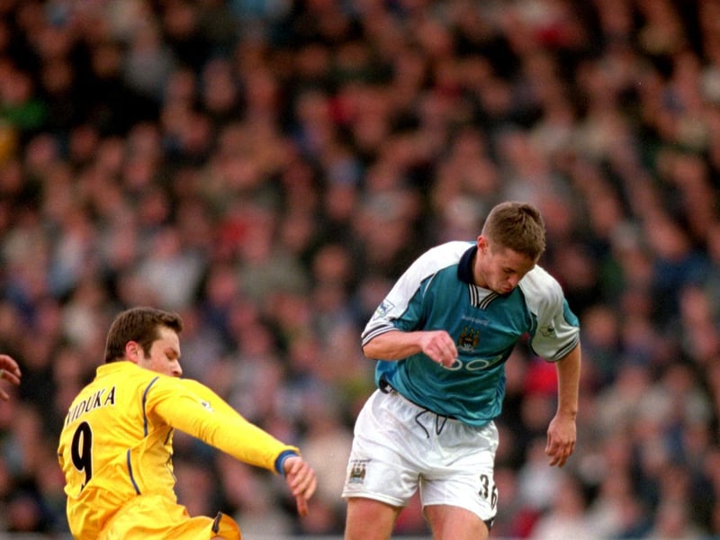 Mark Viduka slides in on Manchester City's Danny Granville.