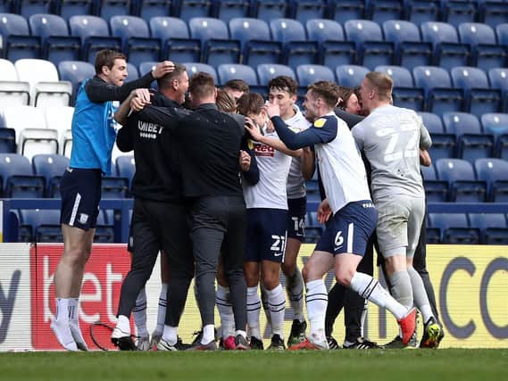 Preston North End players and staff celebrate their stoppage-time equaliser