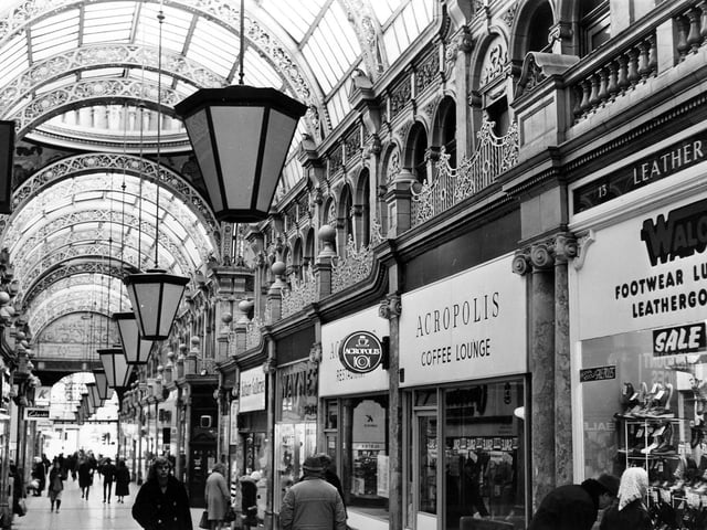 County Arcade looking in the direction of Vicar Lane. Shops include Saltaire Galleries, Waynes shoe shop, Acropolis Coffee Lounge and, at the right edge, Walco Footwear, Luggage and Leathergoods. Pictured in June 1982.