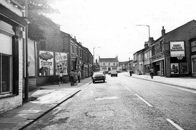 Chapeltown in Pudsey looking towards the Commercial Hotel (centre) which stands at the junction with Uppermoor. There is a sign on a gable end (right) which reads 'Pudsey has it's own Radio Station, Pennine Radio'.