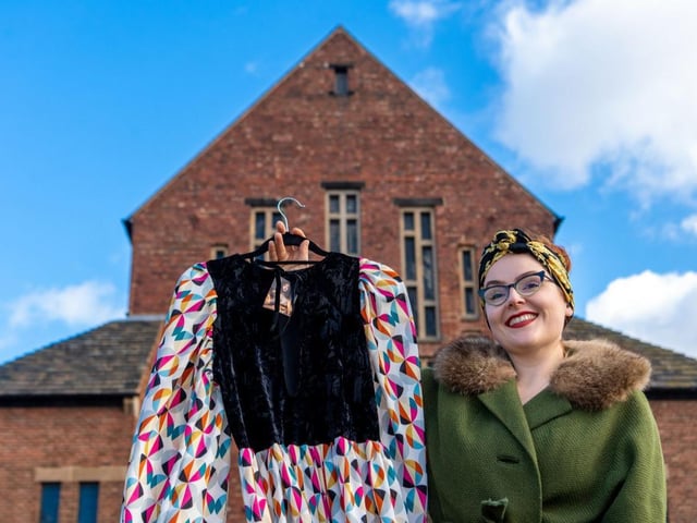 Emily Hughes, Brand & Event Manager of Judys' Vintage Fair, holding a dress from Tallula Vintage