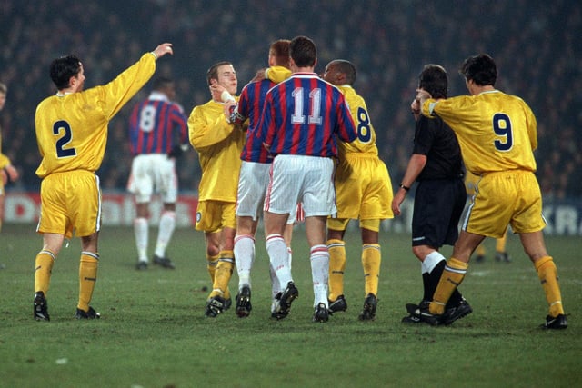 Tempers boil over as Lee Bowyer and Crystal Palace captain David Hopkin are restrained by teammates.