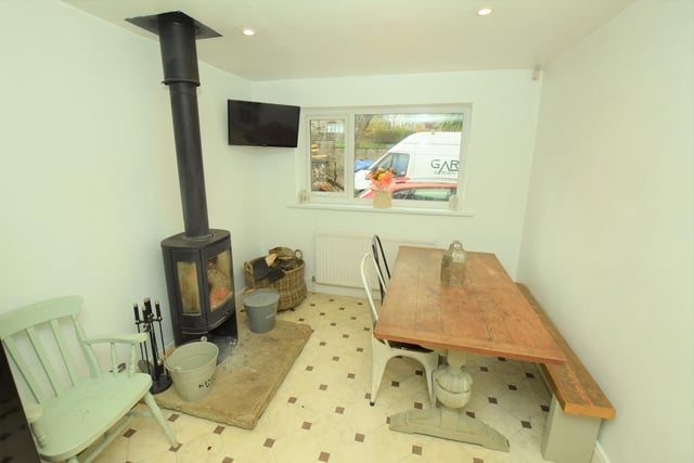 A stove is a feature within this space that could serve as dining area or snug.