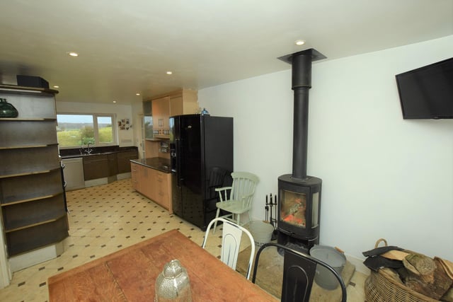 A warming stove serves both kitchen and dining area here.