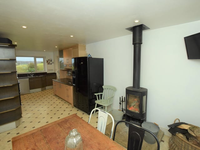 A warming stove serves both kitchen and dining area here.
