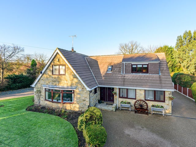 A wide driveway opens up tot he front of the attractive property