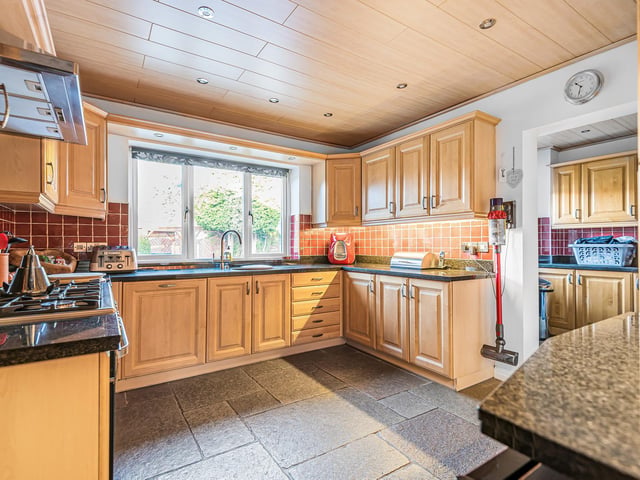 Fitted units with granite worktops line the walls of the kitchen