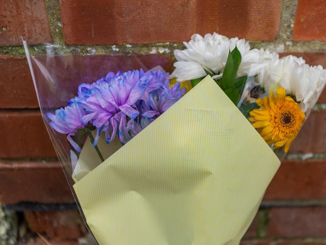 The woman has not been named, and floral tributes were left at the property today.