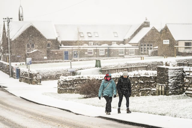 People walk in heavy snow in Hawes, North Yorkshire.
