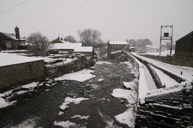 Gayle Mill, (rear right) dating from about 1784, thought to be the oldest structurally unaltered cotton mill in existence covered in a light dusting of snow in Hawes, North Yorkshire