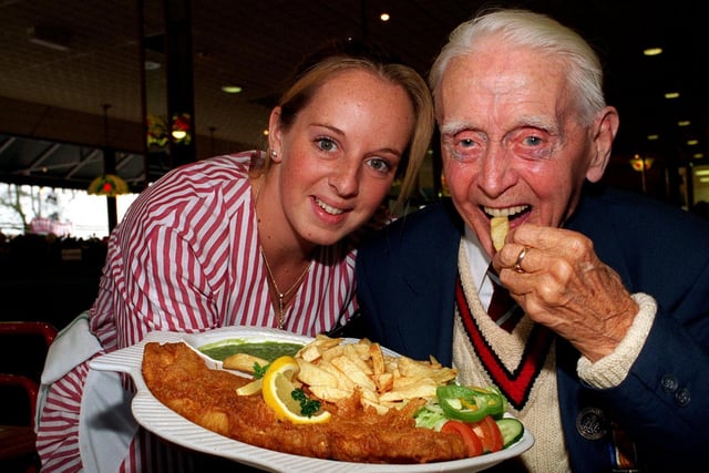 Waitress Nicola Nunns brings Harry Holme fish and chips on his 100th birthday during celebrations at Murgatroyd's restaurant in November 1997.
