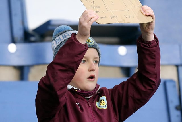 A young Burnley fan holds a sign asking for Nick Pope's shirt