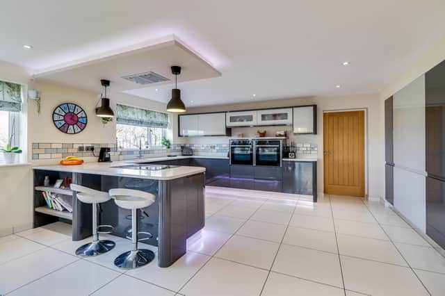 The open plan interior includes a kitchen with dining room, and two sets of patio doors out to the garden.