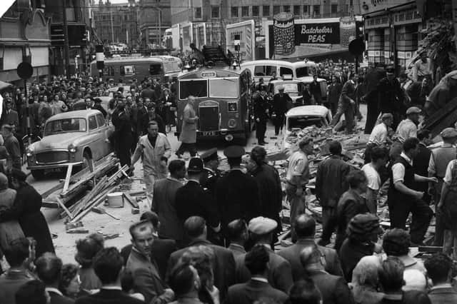 The start of the rescue work as firemen and other helpers move debris in search of trapped people. Three of the floors had ballooned outwards into the street, bringing down with them tons of masonry, including lead-covered rafters and pieces of stonework